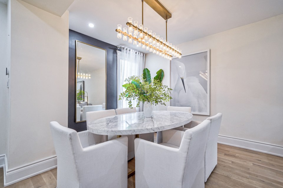 a dining room with a marble table and white chairs