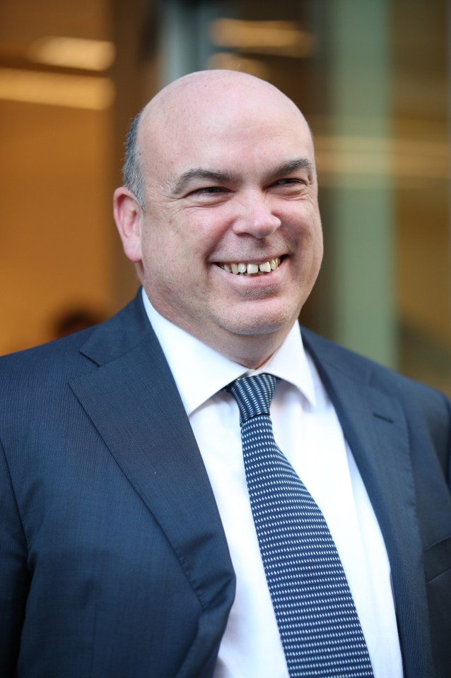 a man in a suit and tie smiles for the camera