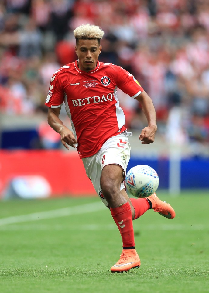 a soccer player wearing a betdaq jersey kicks the ball