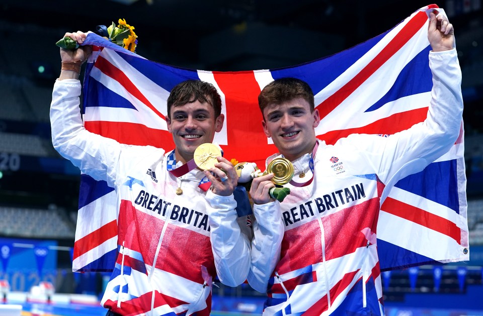 two great britain athletes hold up their gold medals