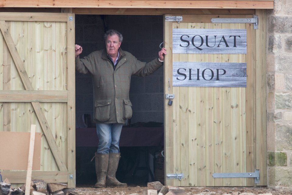 a man stands in the doorway of a squat shop