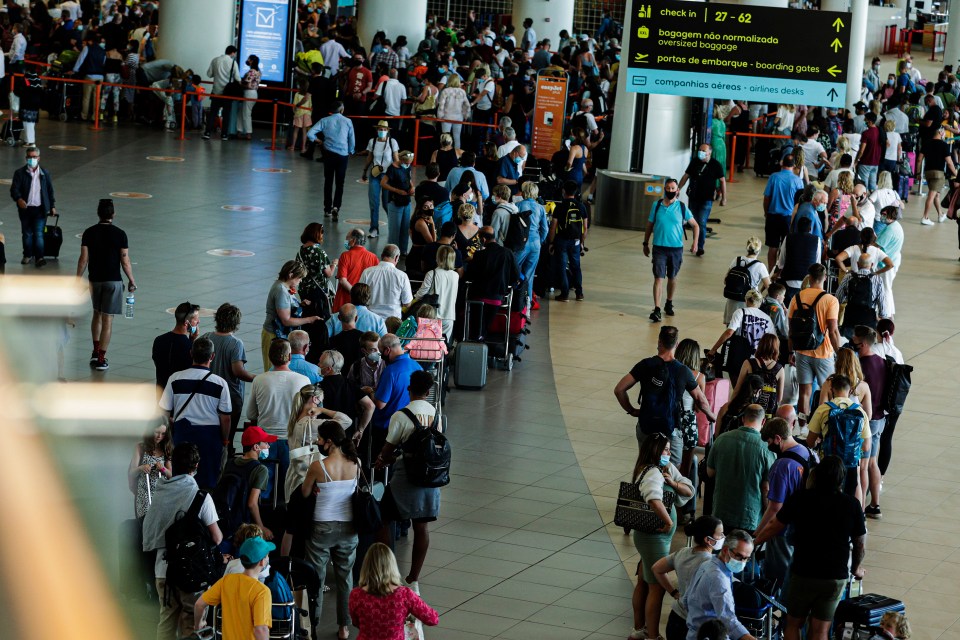 a large group of people are waiting at a check in counter