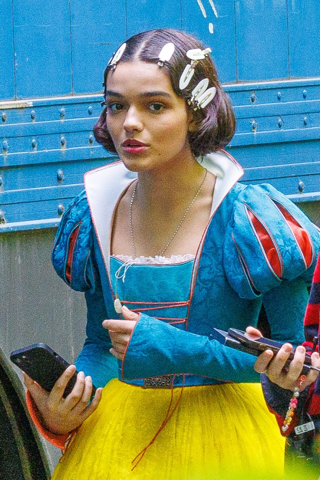 a woman in a snow white costume is holding a cell phone