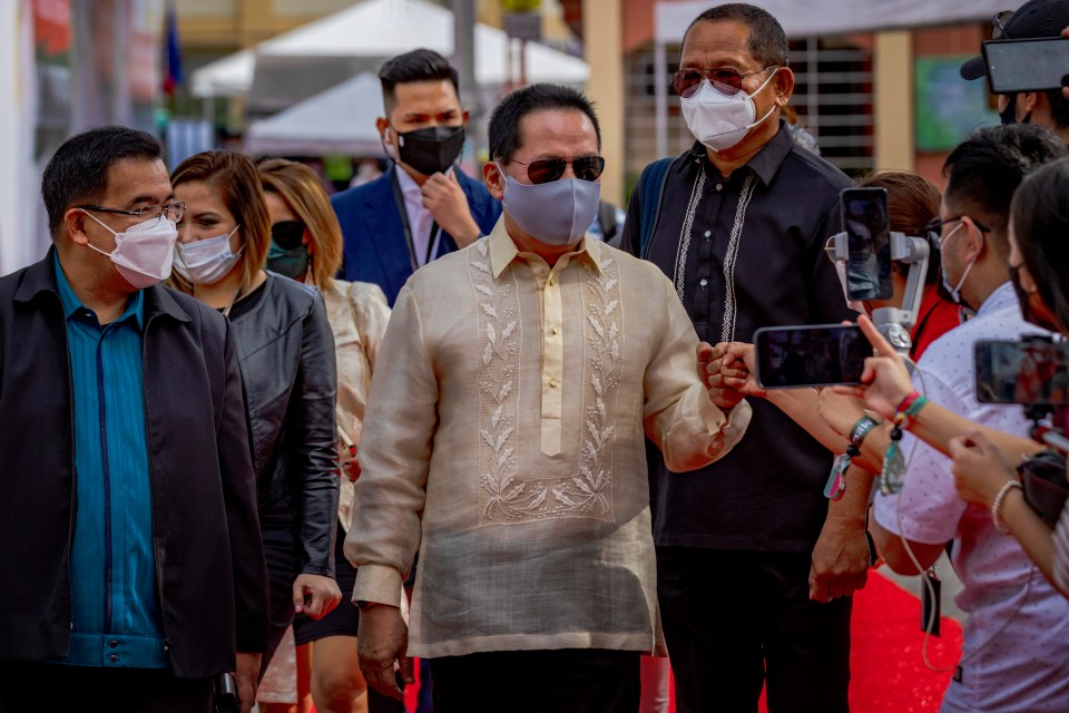 a group of people wearing face masks are walking down a red carpet