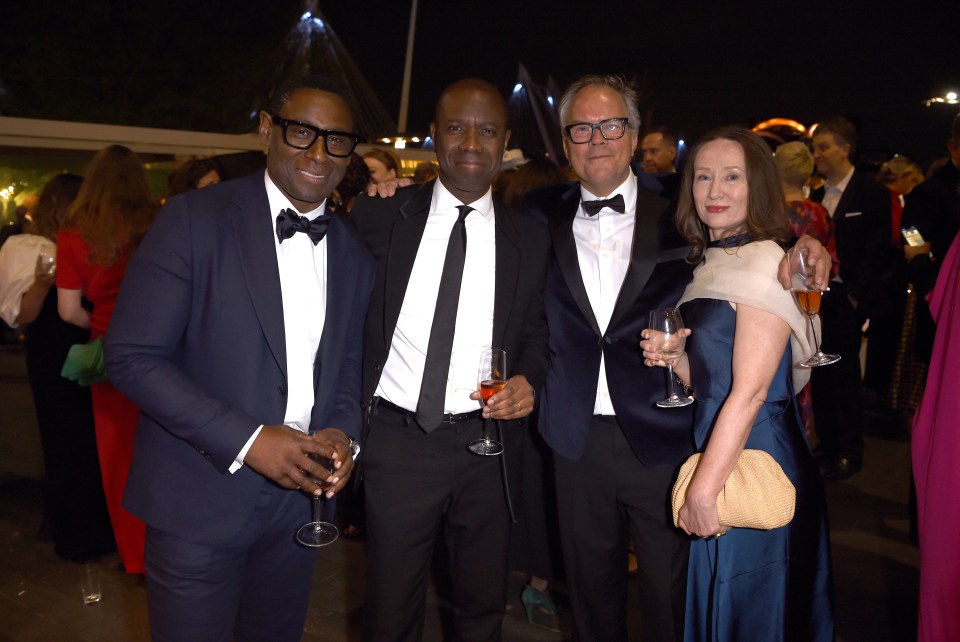 a group of people in tuxedos pose for a photo