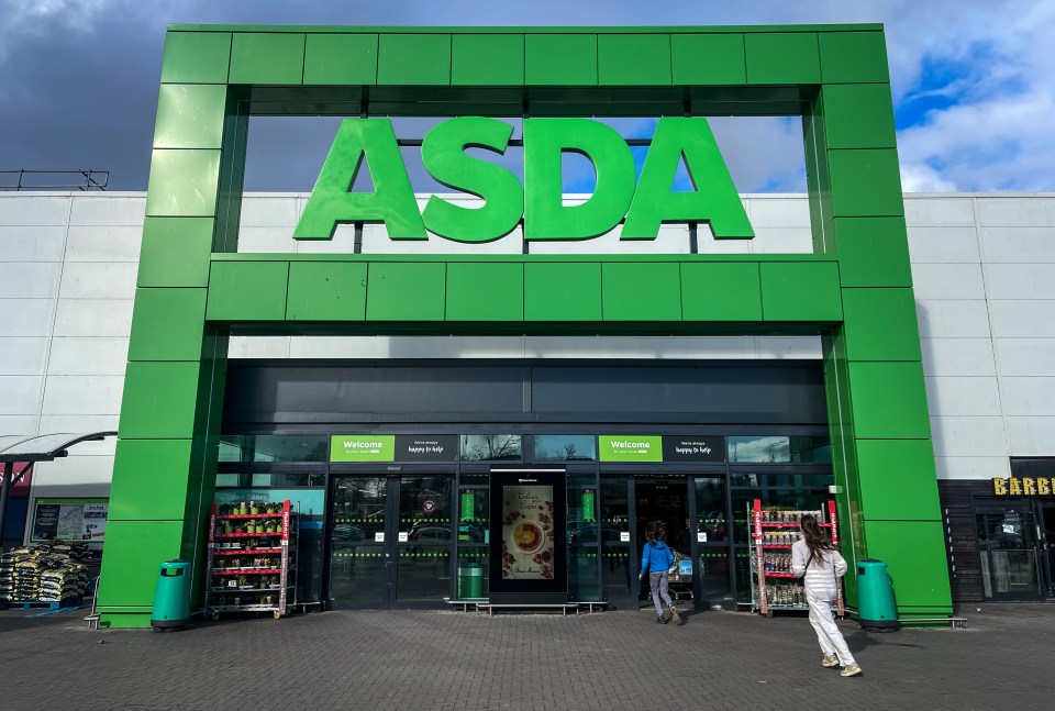 a woman walking in front of a green asda store