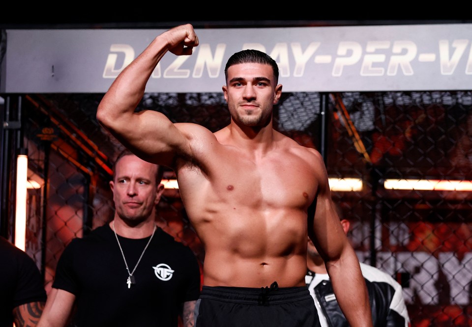 a man flexes his arm in front of a sign that says day-per-v