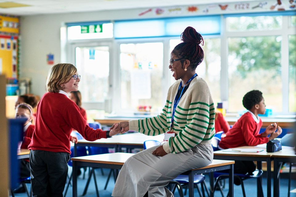 Primary school pupil having fun with teacher, mischief, out of context, informal, modern education