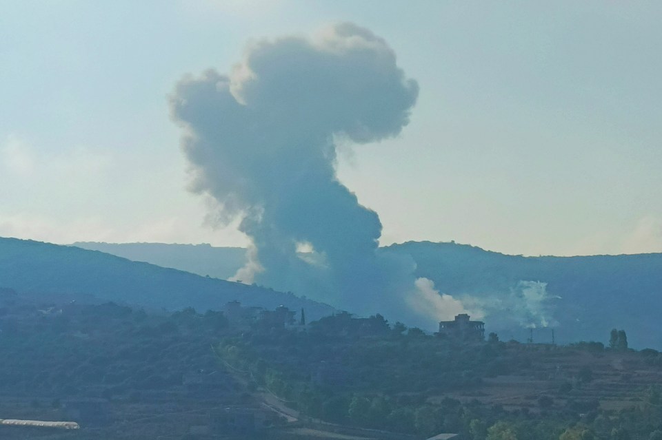 smoke is coming out of a building in the mountains