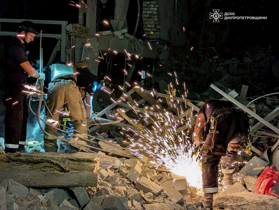 Ukrainian rescuers working at the site of the rocket strike