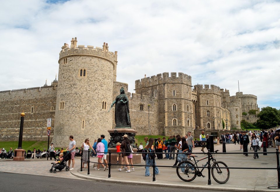 a statue of queen victoria stands in front of a castle