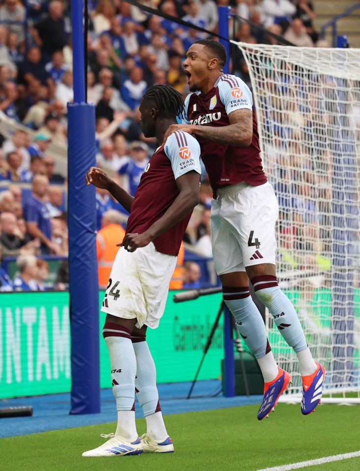 two soccer players are celebrating a goal and one has the number 4 on his jersey