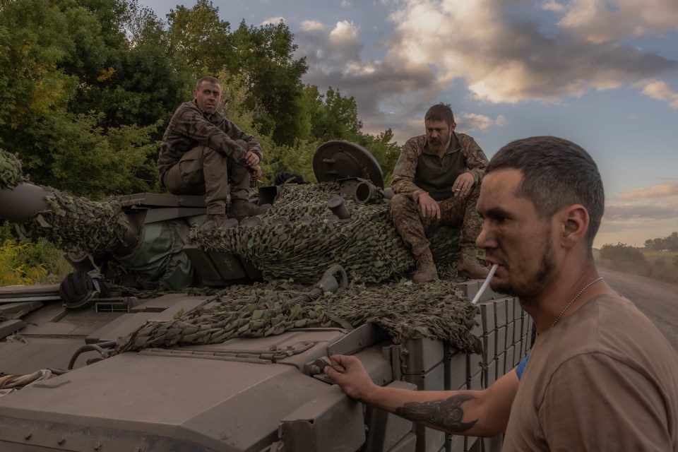 Ukrainian tank crew take a break while operating a tank during the invasion