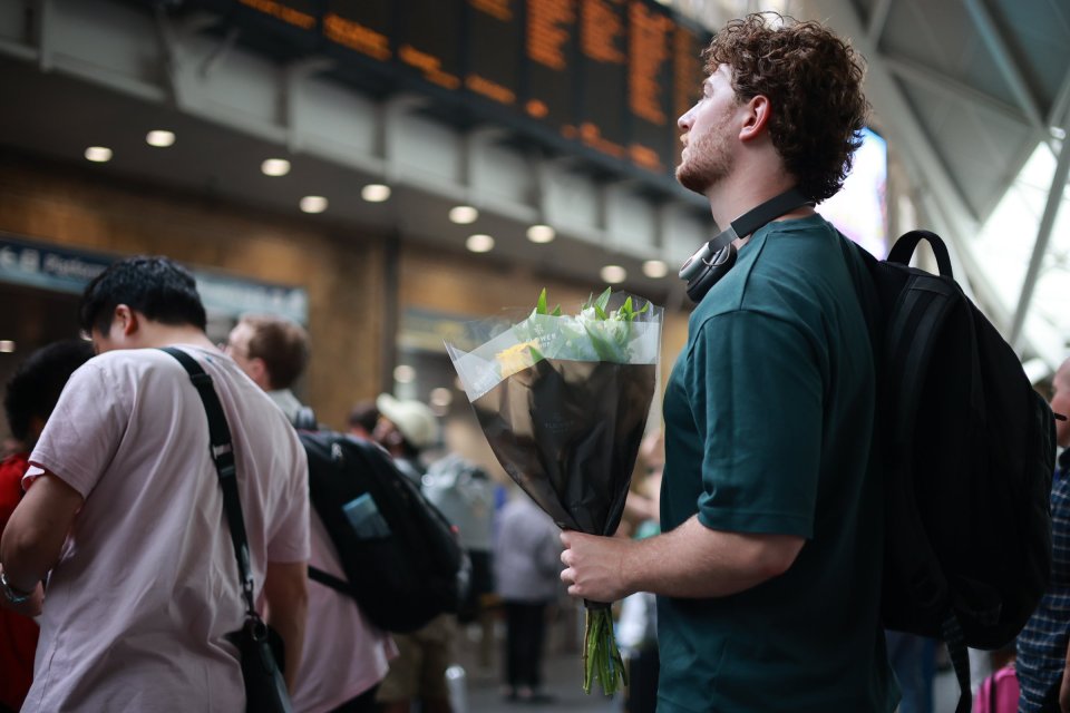 Train travellers scan the boards for news of their train at King's Cross