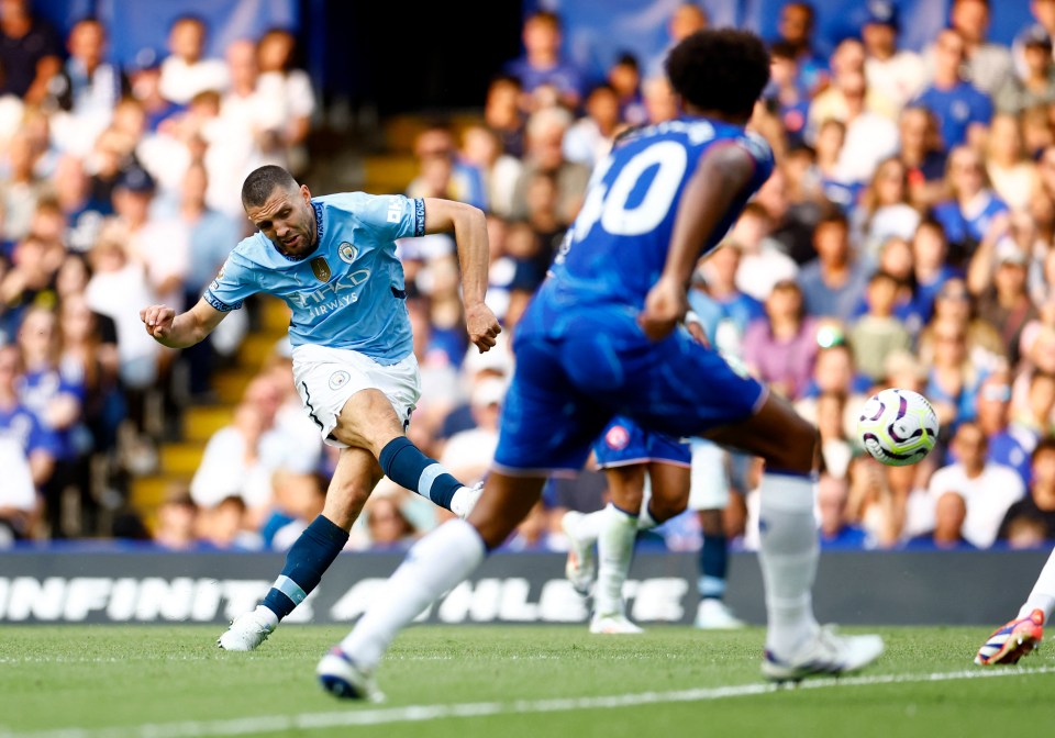 a soccer player wearing a city jersey kicks the ball