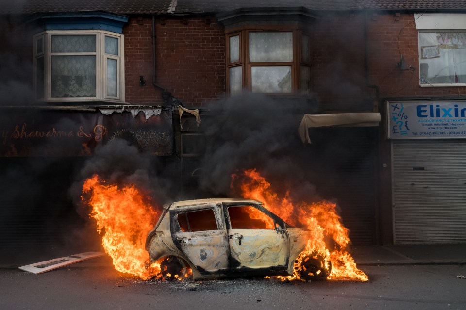 A car burns on Parliament Road, Middlesbrough after being set alight by rioters