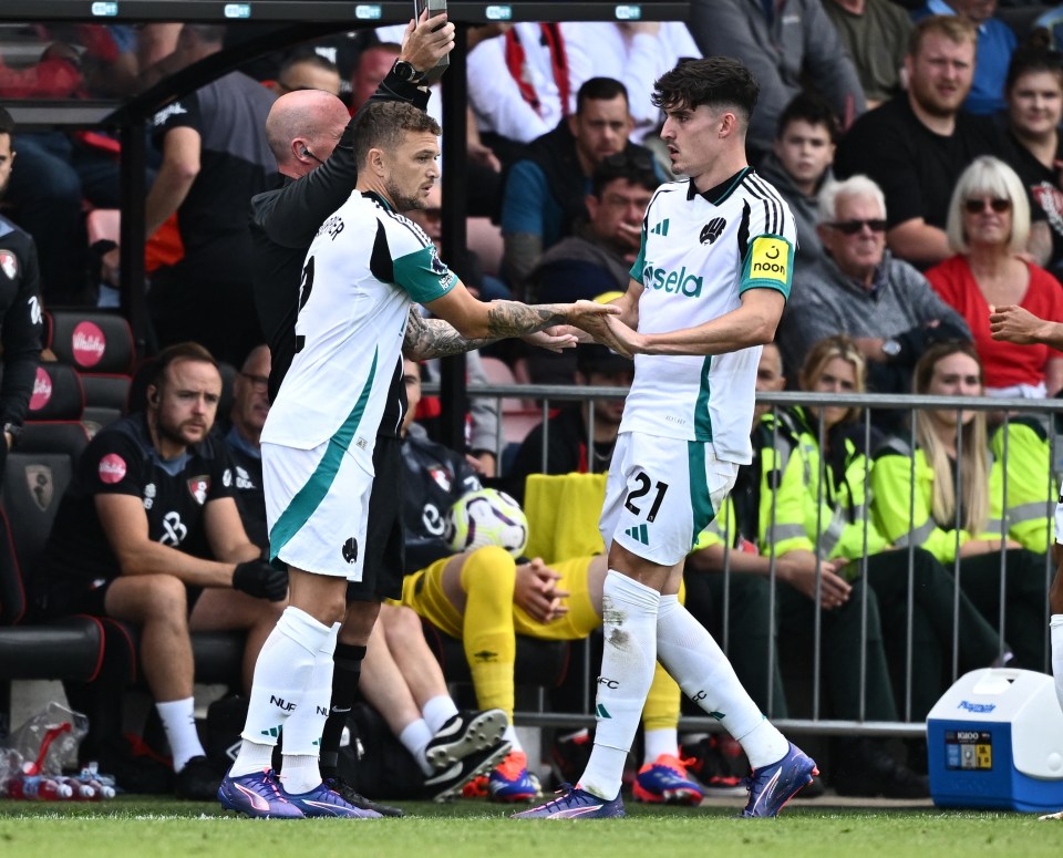 a soccer player with the number 21 on his jersey shakes hands with another player