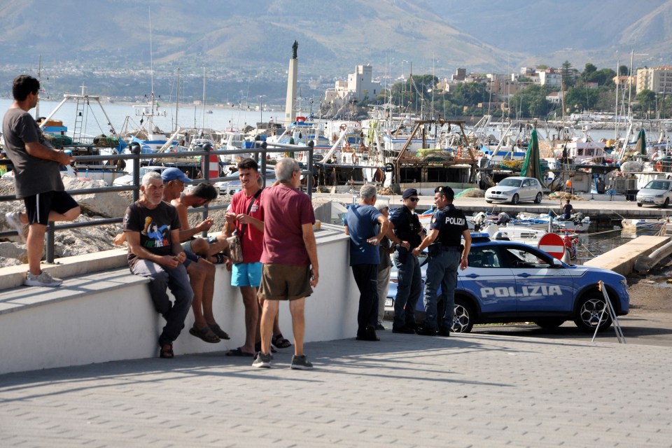 Italian police officers patrol the port as the search continues