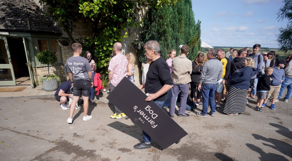 a man carrying a sign that says farmer 's dog