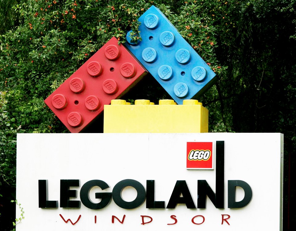 a legoland windsor sign with a large lego brick on top