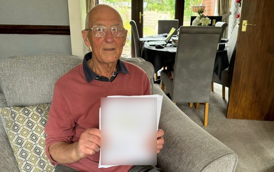 an elderly man is sitting in a chair holding a piece of paper