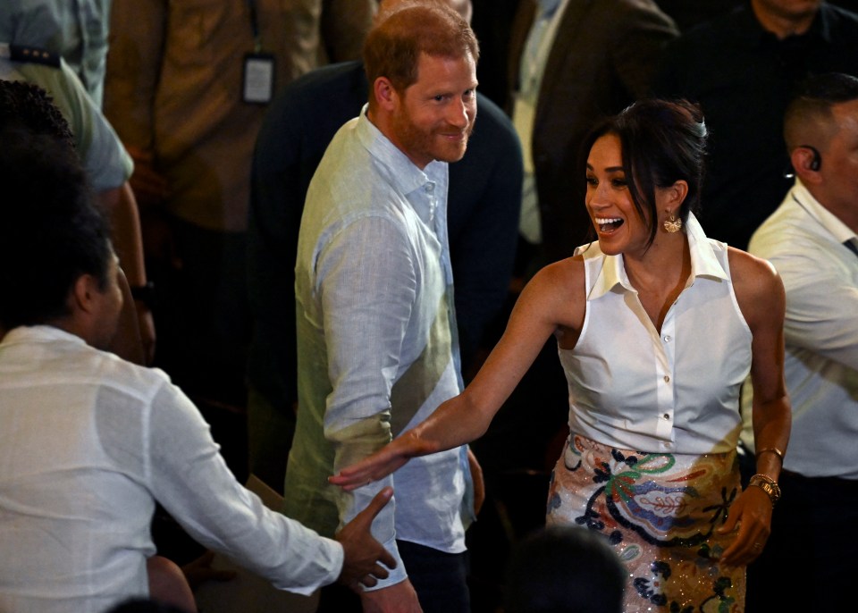 prince harry and meghan markle are dancing in a crowd