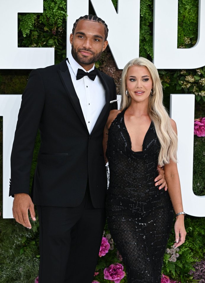 a man in a tuxedo stands next to a woman in a black dress