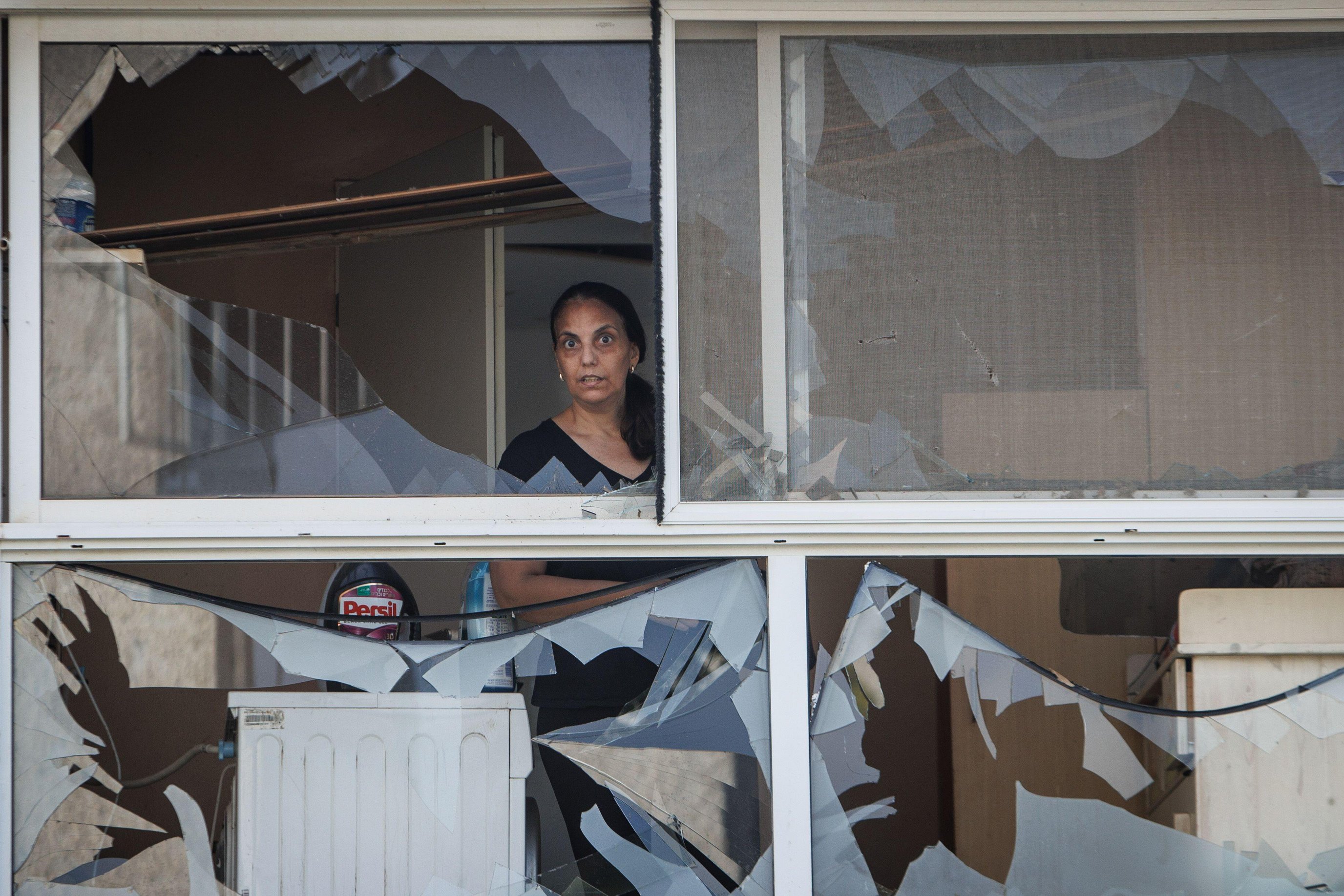 A woman stands in a building hit directly by a rocket fired from Lebanon overnight, in the northern Israeli city of Acre today