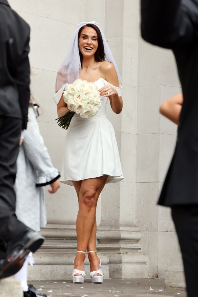 The beautiful bride clutched a bouquet of white roses