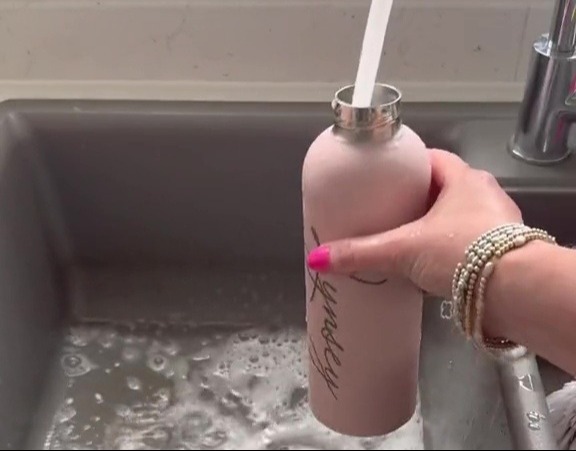 a woman is scrubbing away those black marks and leaving your bottle lovely and clean