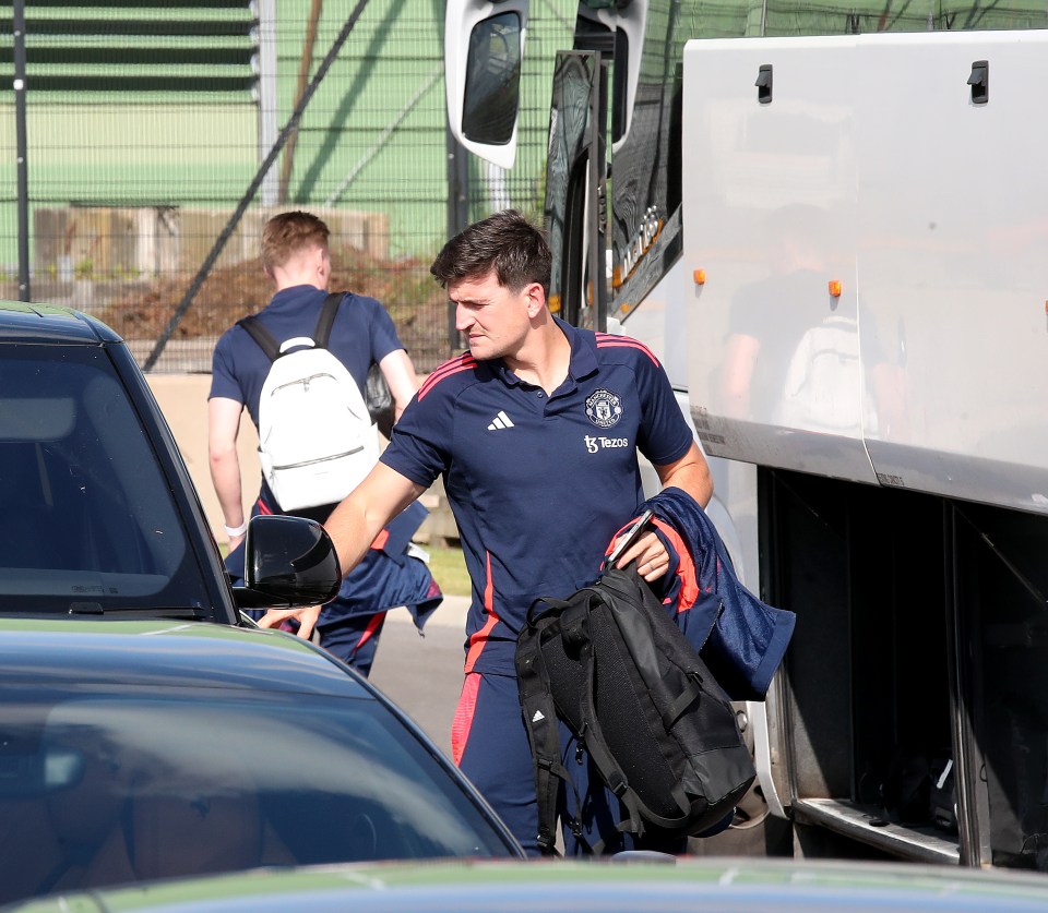 a man wearing an adidas shirt walks towards a bus