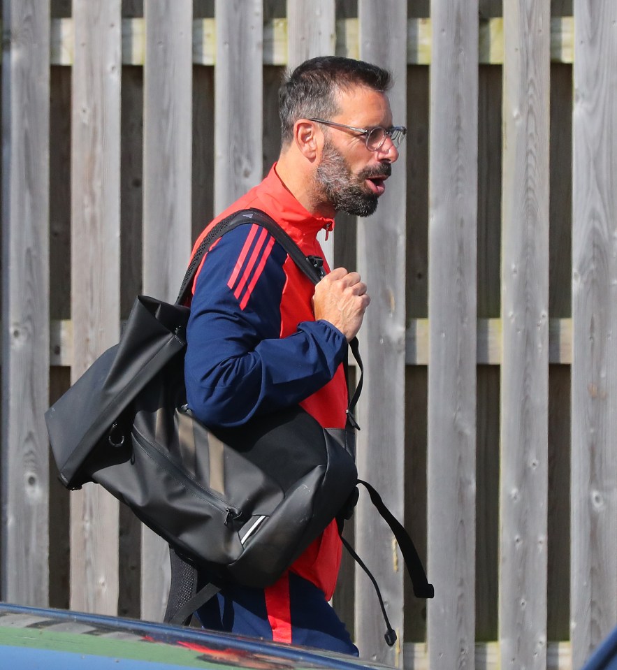 a man in a red and blue adidas jacket carrying a black bag