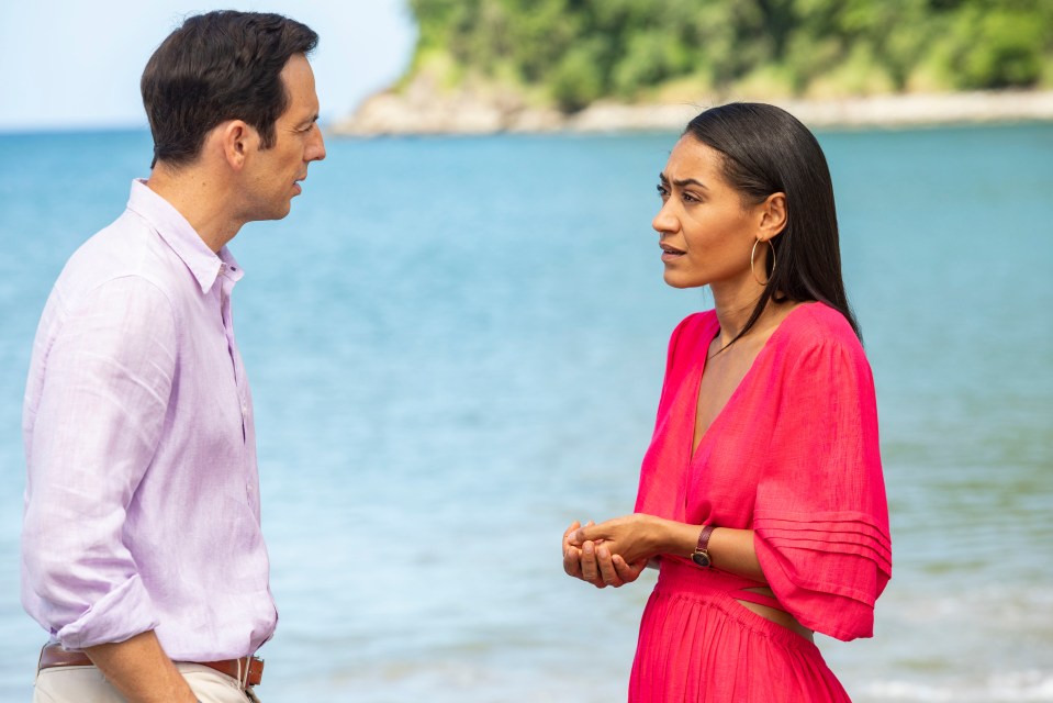 a man and a woman standing on a beach looking at each other