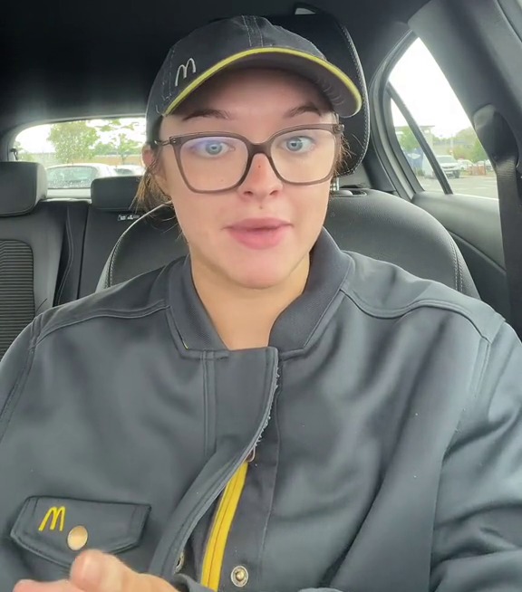 a woman wearing glasses and a hat with the letter m on it