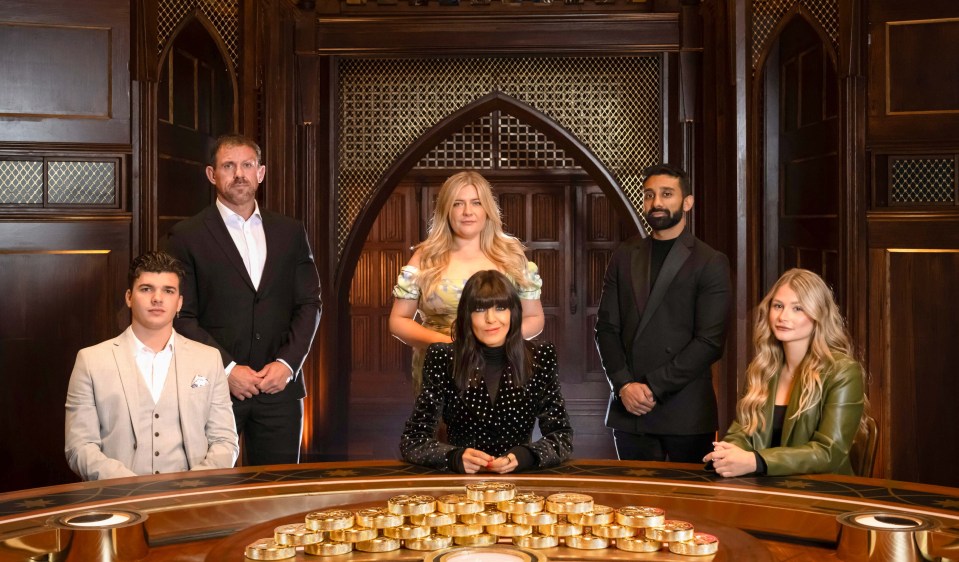 a group of people standing around a table with gold coins on it