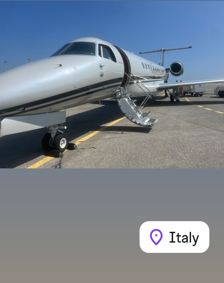 a plane is parked on a runway with italy in the corner