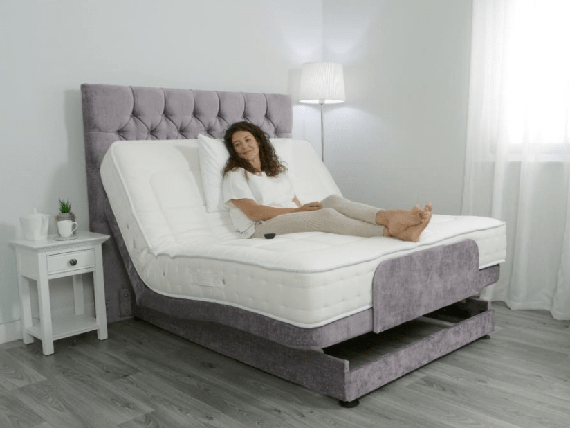 a woman sits on an adjustable bed with her legs crossed