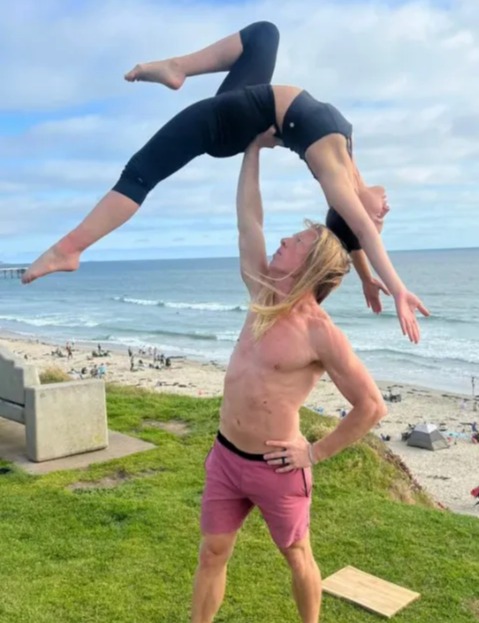 a man is holding a woman up in the air