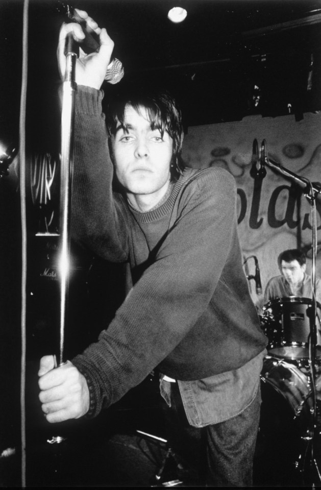 a black and white photo of a man holding a microphone