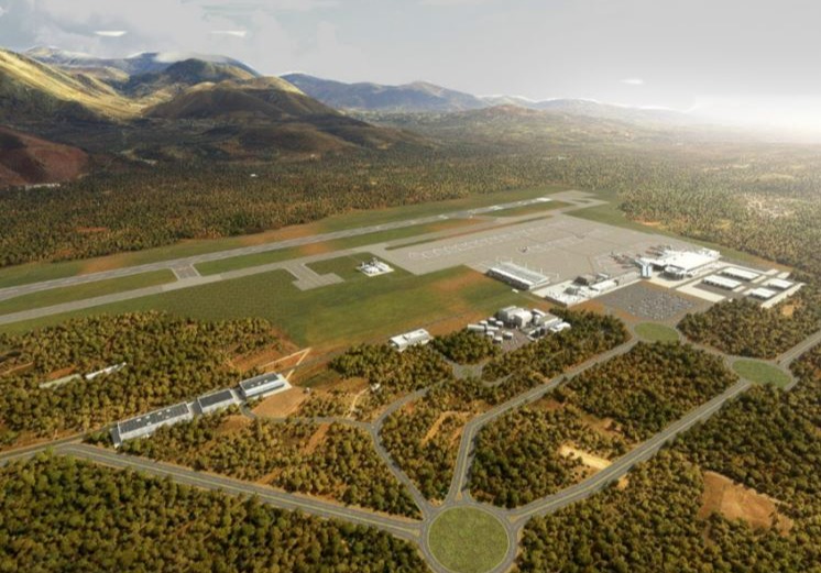 an aerial view of an airport with mountains in the background