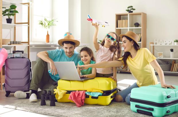 a family is sitting on the floor looking at a laptop