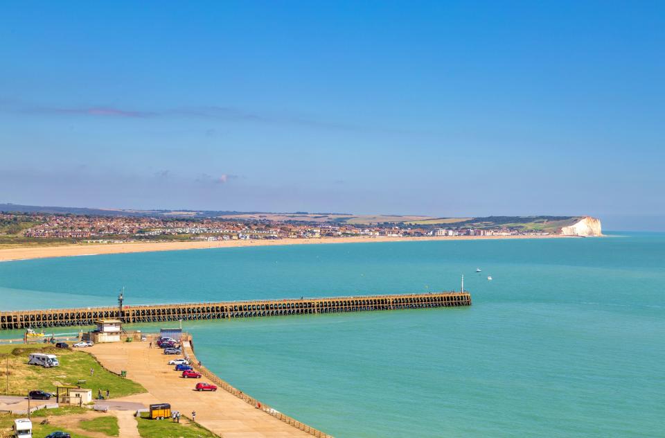 a large body of water with a pier in the foreground