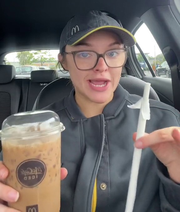 a woman sitting in a car holding a cup of ice cream