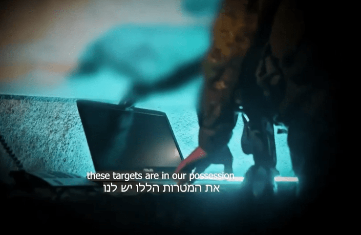 a person standing next to a laptop that says these targets are in our possession