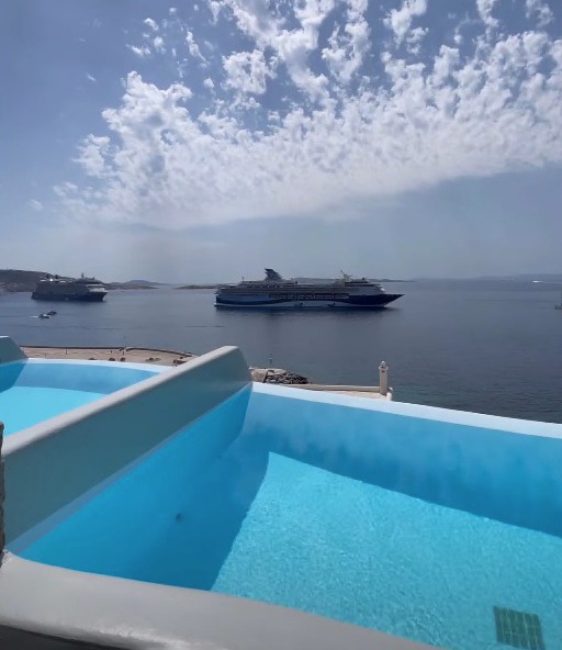 a large cruise ship is floating in the ocean near a swimming pool