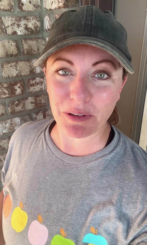 a woman wearing a hat and a shirt with apples on it