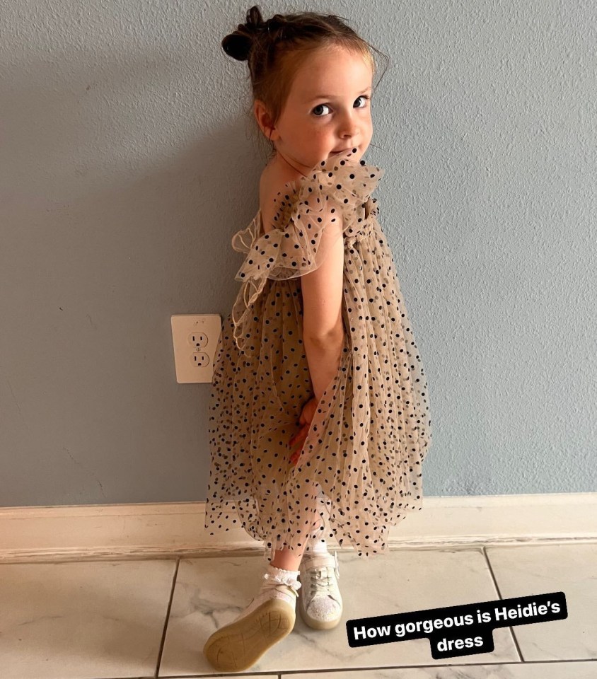 a little girl is wearing a polka dot dress