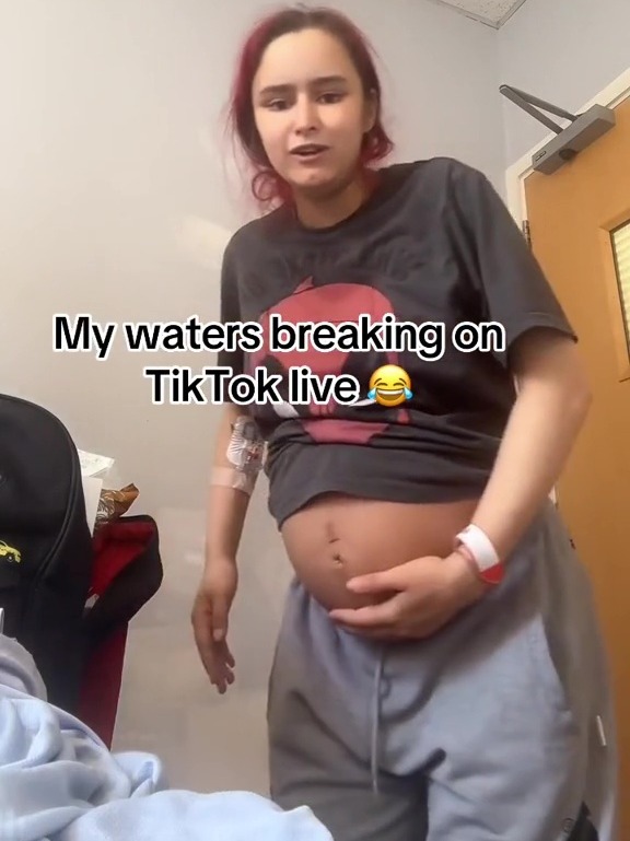 a pregnant woman is standing in a room with the caption " my waters breaking on tiktok live "