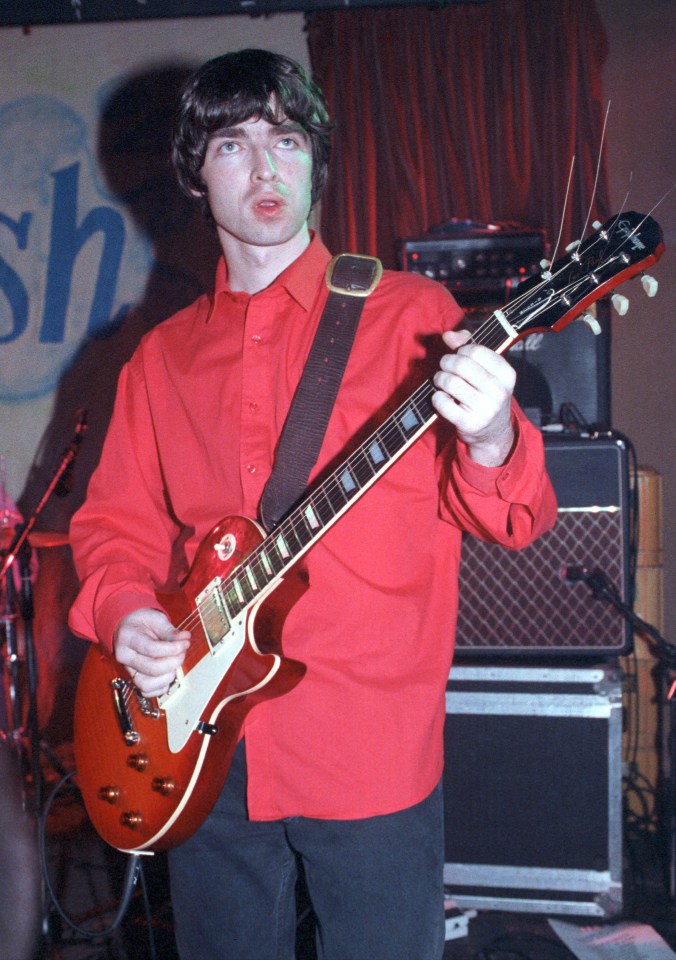 a man in a red shirt is playing a guitar