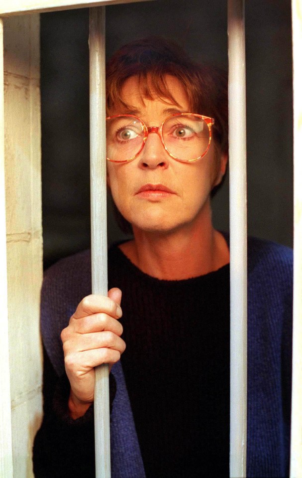 a woman wearing glasses is behind bars